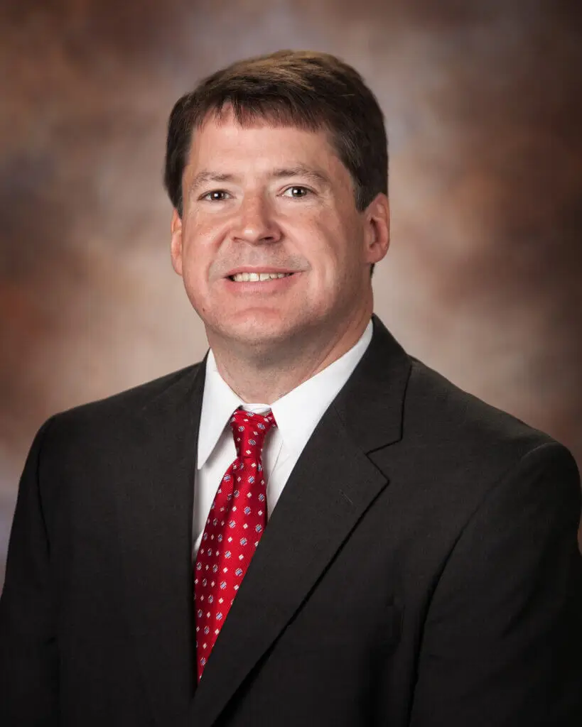 Scott W. Sims MD cardiologist with Montgomery Cardiovascular Associates wearing a suit and tie on neutral background